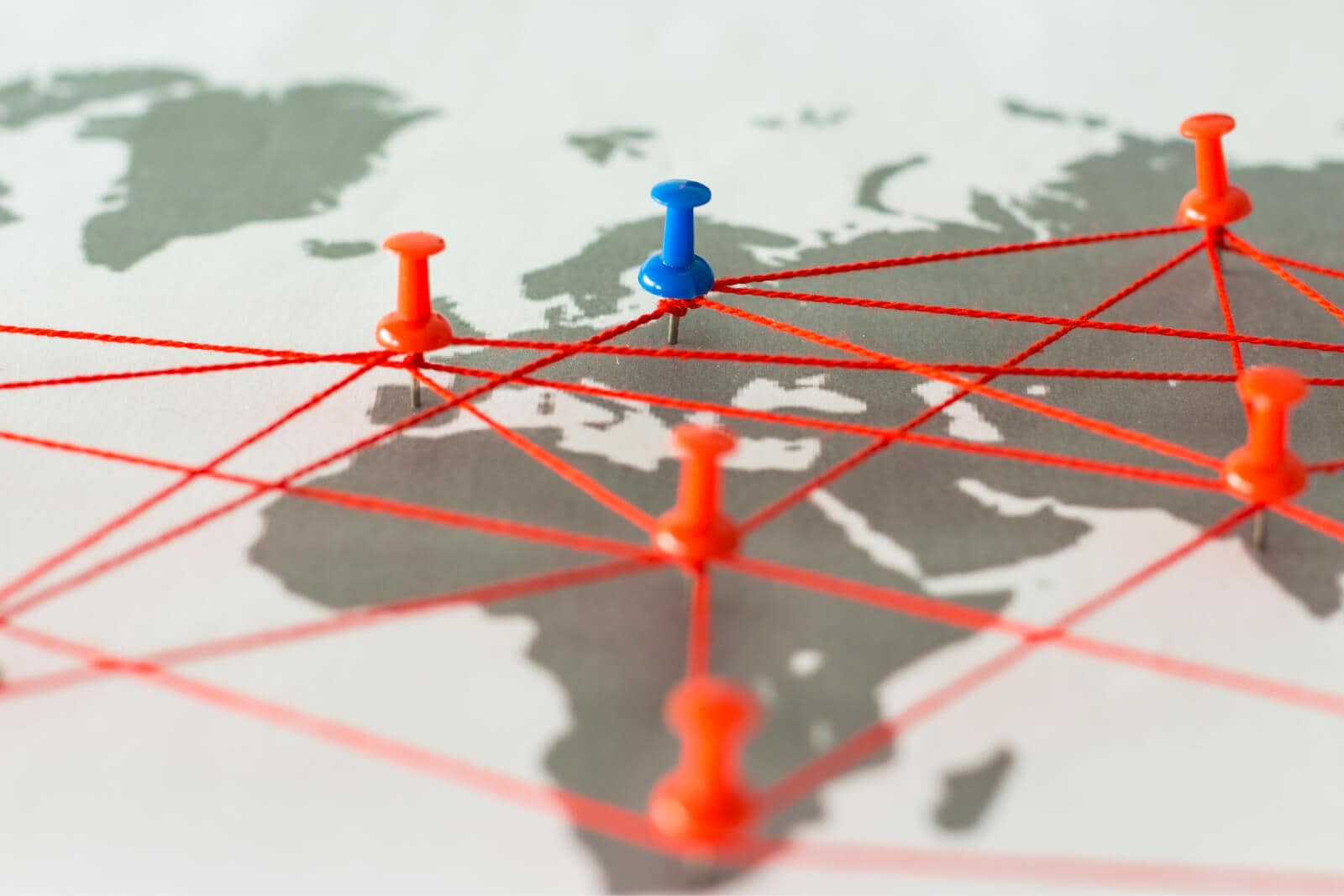 Map with pushpins and string representing supply chain collaboration