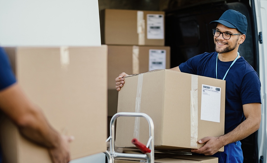 Man holding a large brown box as part of the parcel tracking process