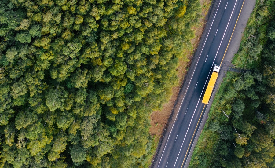 Visão aérea de um caminhão de carga amarelo na estrada Visão aérea de um caminhão de carga amarelo na estrada