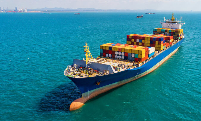 Ocean shipping vessel at sea loaded with brightly colored cargo containers